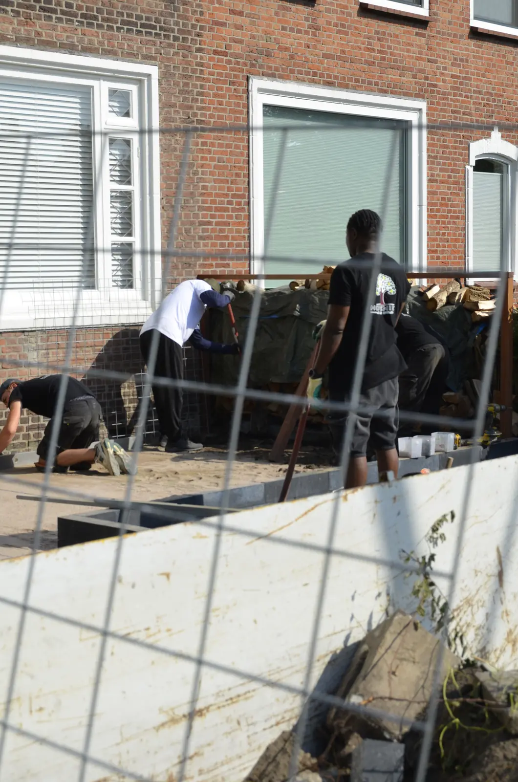 Het team werkt aan de voortuin, de wand is half gevuld — Rotterdam-Schiebroek