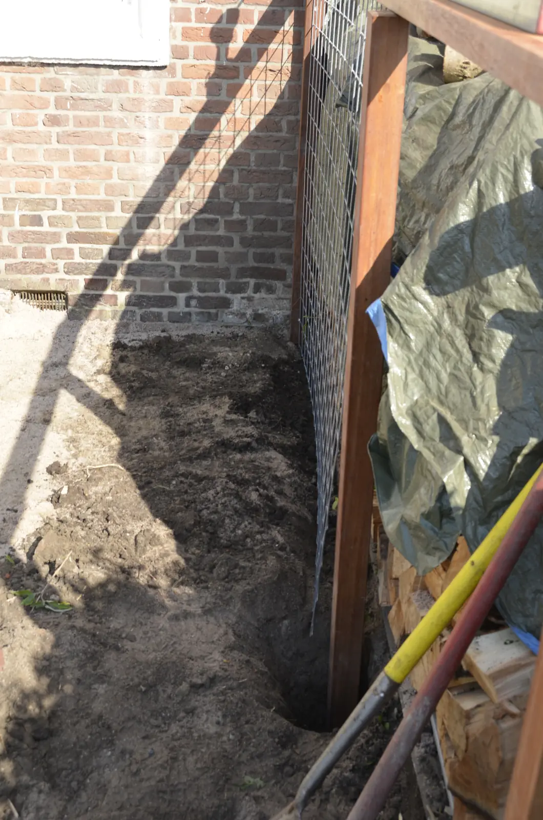 Uitgegraven sleuf langs de gevel voor de fundering van de wand — Rotterdam-Schiebroek